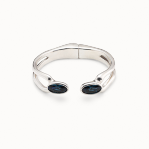 Open bracelet featuring a chandelier component link design with a blue crystal at each end. It has a subtle spring allowing it to be slipped on and adjusted with ease.