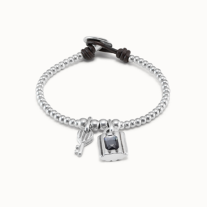 This bracelet from the Confident collection features a design of small beads in the shape of balls. There are two charms in the center, one in the shape of a padlock with a central silver-gray crystal and the other in the shape of a key.
