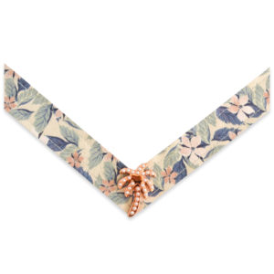 The Penelope Strap is a green, pink, and purple floral print on a cream base strap with a rose gold and pearl palm tree ornament.